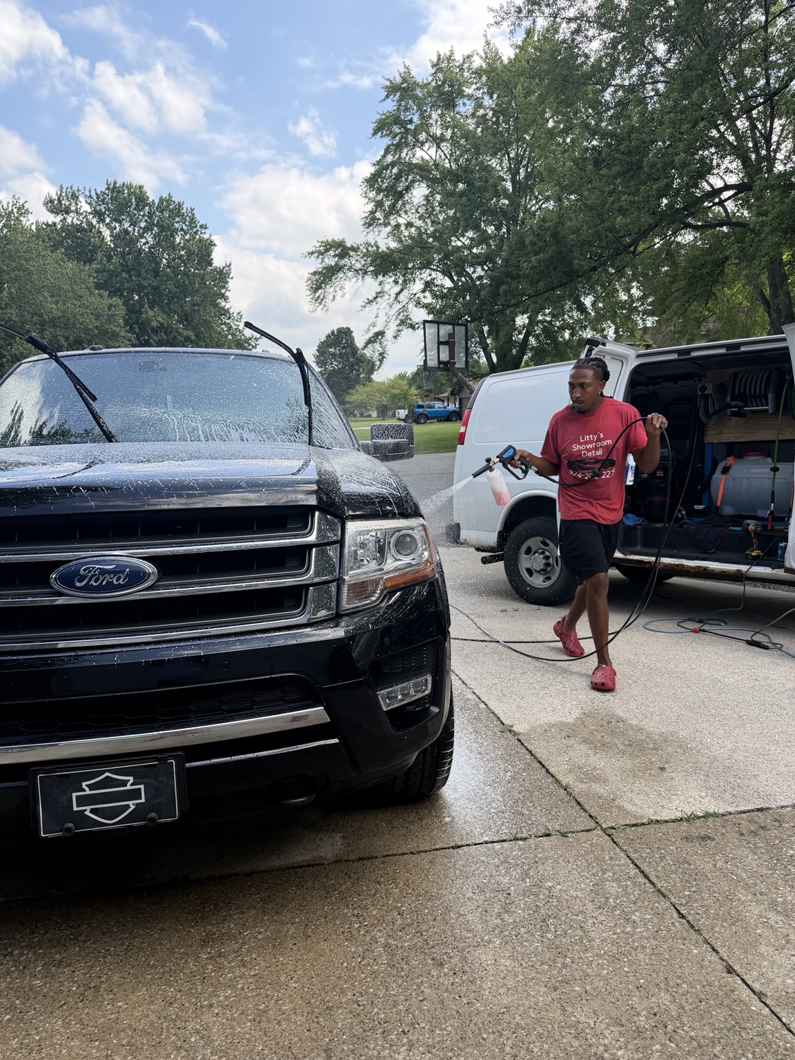 Litty's Showroom Detail washing a black SUV