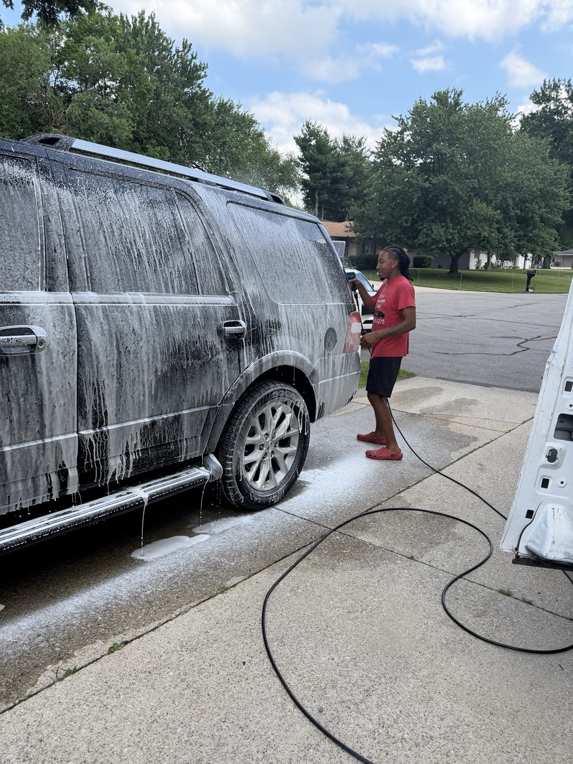 Mobile detailing van beside a black SUV