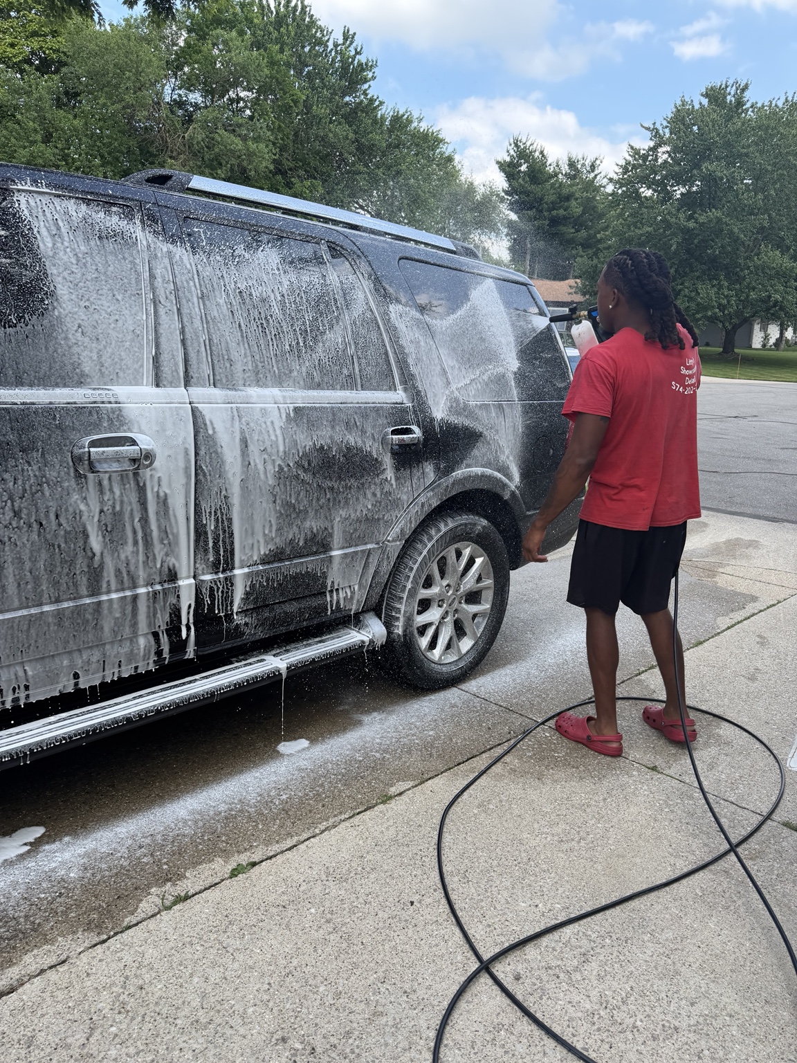 Foam wash being applied to a black SUV